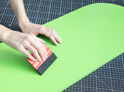 Rakel streicht &uuml;ber die Klebefolie.