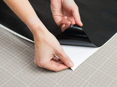 Das Rückseitenpapier der Klebefolie wird abgezogen.