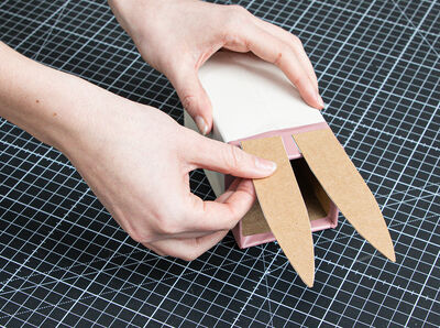 Hand befestigt Ohr am Milchkarton r&uuml;ckseitig. 