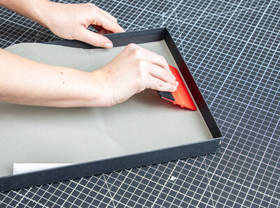 Hand h&auml;lt Rakel und bearbeitet eine Innenkante.