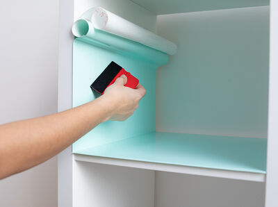 Rakel streicht die Klebefolie fest.