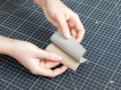 Papierrollen-H&auml;lfte wird mit Folie beklebt.