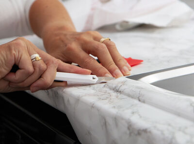 Klebefolie wird mit einem Cutter abgeschnitten.