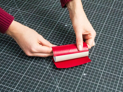 Klopapierrolle wird mit Folie beklebt.