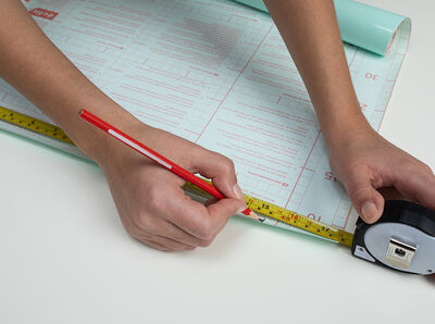 Folie wird mit einer Schere zugeschnitten.