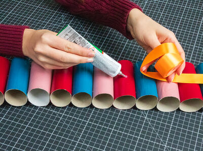 Geschenkband wird auf die Rollen geklebt.