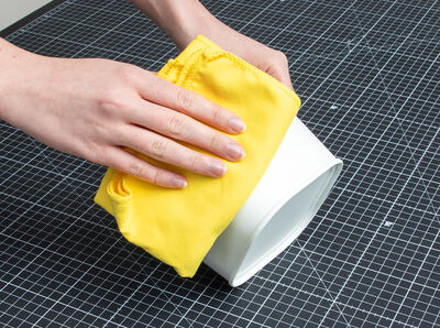 Hand h&auml;lt Tuch und reibt Oberfl&auml;che von &Uuml;bertopf. 