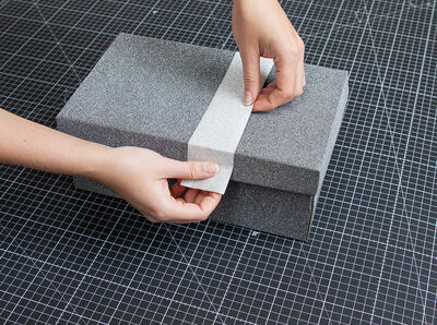 Glitter silver foil is placed on the lid and pressed down on the side by hand.