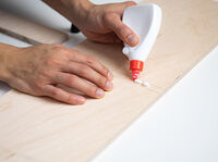 Tragt dann Holzleim auf die Unterseite der drei Abstandsbalken auf.