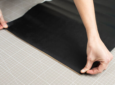 Klebefolie wird an der Kante der Platte angesetzt.