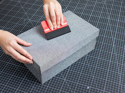 Anthracite foil is squeegeed onto the shoe box.
