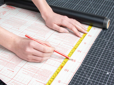 Stift zeichnet Markierung auf Rasterpapier. 