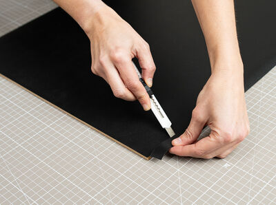 Überstehende Folie wird mit einem Cutter abgeschnitten.